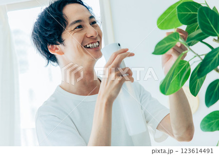 観葉植物に水をあげる男性 123614491