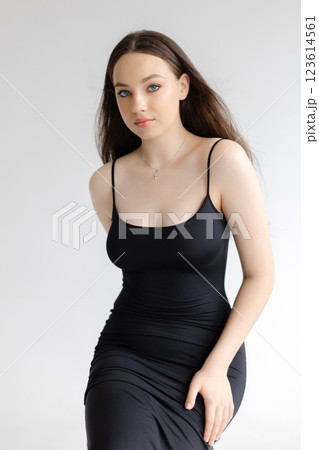 Fashion model posing wearing a tight black dress sitting on a stool Fashion model posing wearing a tight black dress sitting on a stool 123614561