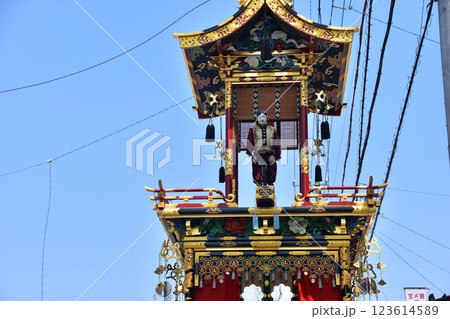 日本の岐阜県の高山市　春の高山祭　巡行する唐子の人形屋台と豪華な装飾　周辺の街並みと美しい青空 123614589
