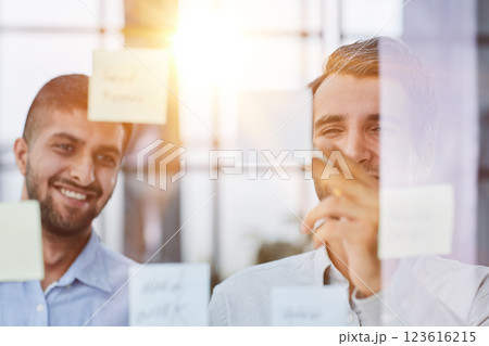 two successful businessmen in the office discuss a plan on stickers two successful businessmen in the office discuss a plan on stickers 123616215