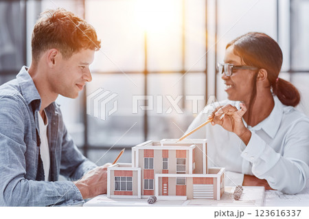 young man and woman designers architects discussing house designs 123616337