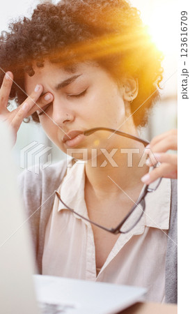 woman in the office is tired of working on the computer. took off her glasses and rubs her eyes 123616709