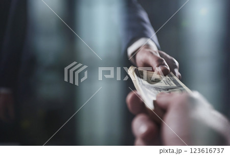 Businessman taking a bribe from a colleague on a black background 123616737