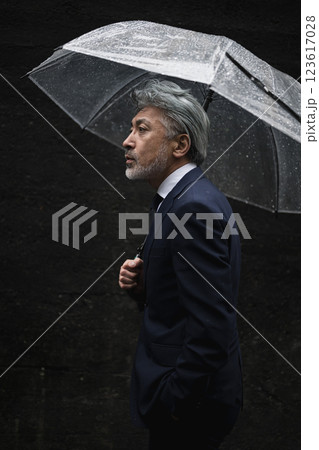 雨の中、傘をさす男性 123617028