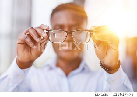 a black man in a blue shirt adjusts his glasses. a black man in a blue shirt adjusts his glasses. 123617473