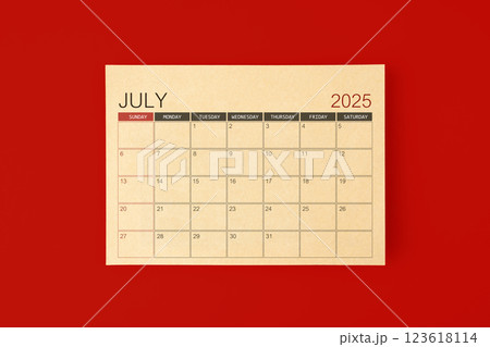 July 2025 desk calendar made from brown paper page on red background. 123618114