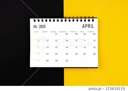 April 2025 desk calendar on black and yellow background, Flat lay. April 2025 desk calendar on black and yellow background, Flat lay. 123618119