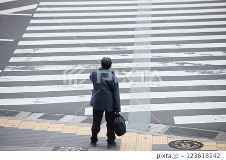 冬の都市の交差点で信号待ちの一人の中年サラリーマンの姿 123618142