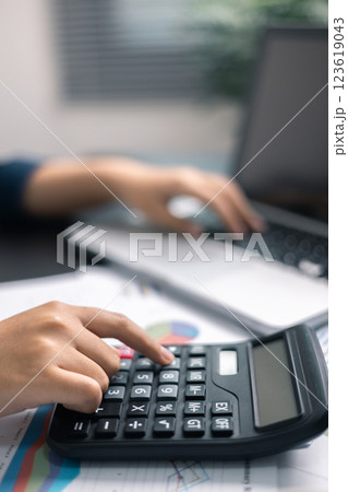 Finance bank tax expense accounting budget money businessman hand use calculator Financial calculate accountant close up calculator with graph chart write office desk Business expense analysis saving 123619043