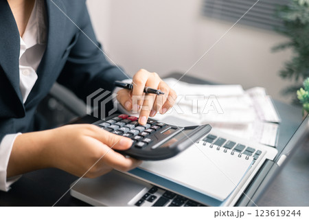 Finance bank tax expense accounting budget money businessman hand use calculator Financial calculate accountant close up calculator with graph chart write office desk Business expense analysis saving 123619244