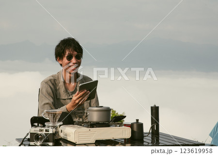 Young business man working computer on peak hill. Hiker online shopping on laptop at sunset, sunrise on top mountain, freelance person remote work with digital tablet. travel vacation holiday concept 123619958