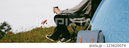 Man traveler with backpack hiking outdoor travel lifestyle and adventure concept. join of tourist for green mountain tour beauty of nature and expansive sky people of tourism. banner with copy space 123620074