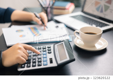 Finance bank tax expense accounting budget money businessman hand use calculator Financial calculate accountant close up calculator with graph chart write office desk Business expense analysis saving 123620122