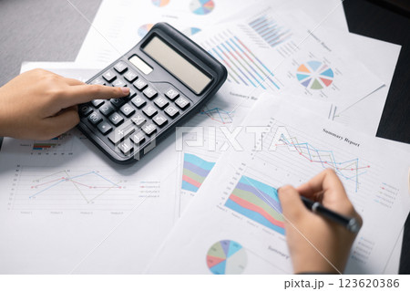 Finance bank tax expense accounting budget money businessman hand use calculator Financial calculate accountant close up calculator with graph chart write office desk Business expense analysis saving 123620386