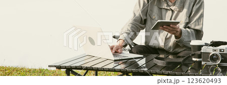 Young business man working computer on peak hill. Hiker online shopping on laptop at sunset, sunrise on top mountain, freelance person remote work with digital tablet. travel vacation holiday concept 123620493