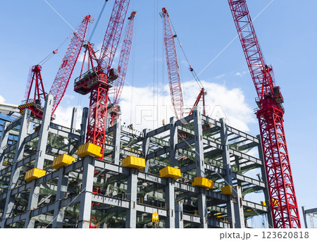Low-angle view of cranes and steel structures of building construction with a blue sky background in Taiwan. Low-angle view of cranes and steel structures of building construction with a blue sky background in Taiwan. 123620818