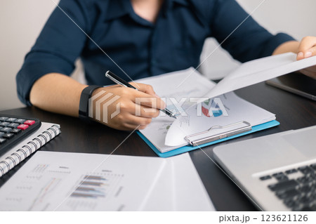 Finance bank tax expense accounting budget money businessman hand use calculator Financial calculate accountant close up calculator with graph chart write office desk Business expense analysis saving 123621126