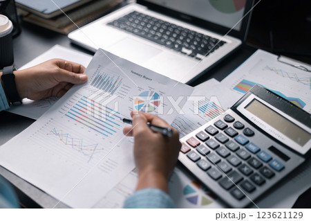 Finance bank tax expense accounting budget money businessman hand use calculator Financial calculate accountant close up calculator with graph chart write office desk Business expense analysis saving 123621129