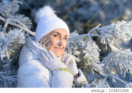 Beautiful elderly woman posing in a snowy winter park 123621268