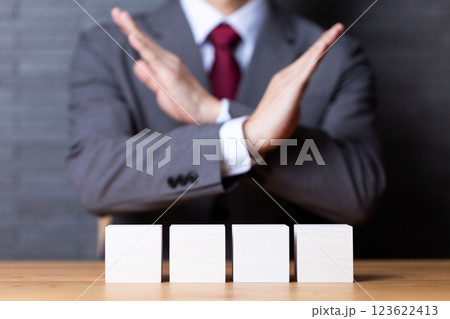 4つの白い木のブロックとバツサインをするミドル男性ビジネスマン 123622413