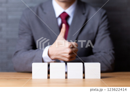 4つの白い木のブロックと親指を立てるミドル男性ビジネスマン 123622414