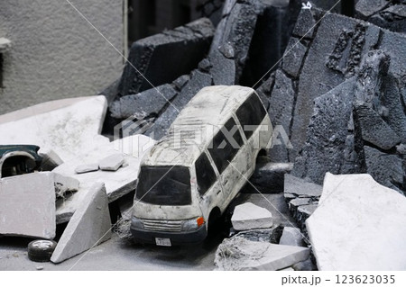 崩壊したビルの下敷きになったクルマのミニチュア 123623035