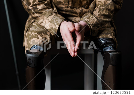 A Remarkable Representation of Resilience: A Man Sitting with a Bionic Leg Prosthesis in Military Camouflage 123623551