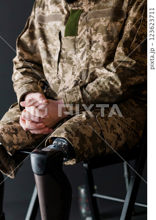 Soldier with Bionic Leg Prosthesis Seated in Camouflaged Uniform Soldier with Bionic Leg Prosthesis Seated in Camouflaged Uniform 123623711
