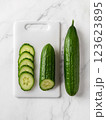 Raw green cucumbers on a white cutting board. 123623895