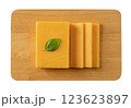 Sheddar cheese slices on a cutting board cutout. 123623897