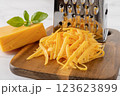 Whole and grated cheddar cheese close-up. 123623899