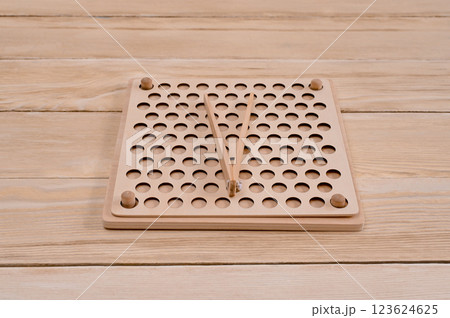 Wooden Montessori sorting board on the table. Children's educational wooden toy. Colorful balls with tweezers. Learning colors. Montessori concept 123624625