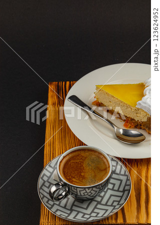 Delicious cheesecake and rich coffee enjoyed on a wooden table Delicious cheesecake and rich coffee enjoyed on a wooden table 123624952