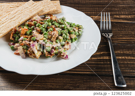 Savory green peas salad served with crispy flatbread on a wooden table Savory green peas salad served with crispy flatbread on a wooden table 123625002