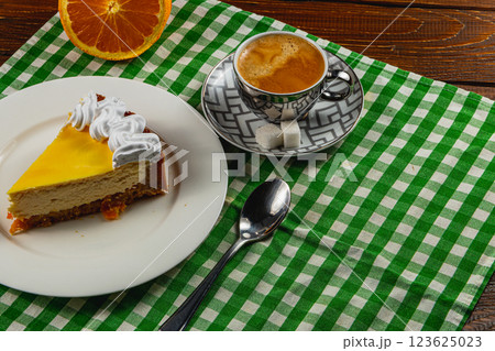 Citrus cheesecake with espresso on a cozy table setting Citrus cheesecake with espresso on a cozy table setting 123625023