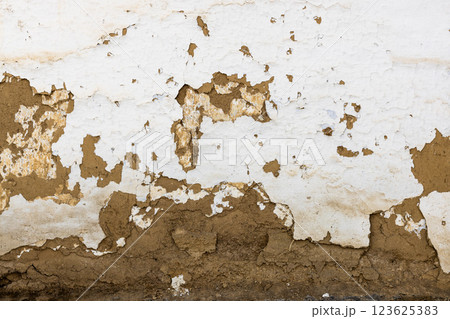 Textured adobe Wall with Peeling White Plaster That Exhibits a Unique and Rustic Feel and Charm Textured adobe Wall with Peeling White Plaster That Exhibits a Unique and Rustic Feel and Charm 123625383