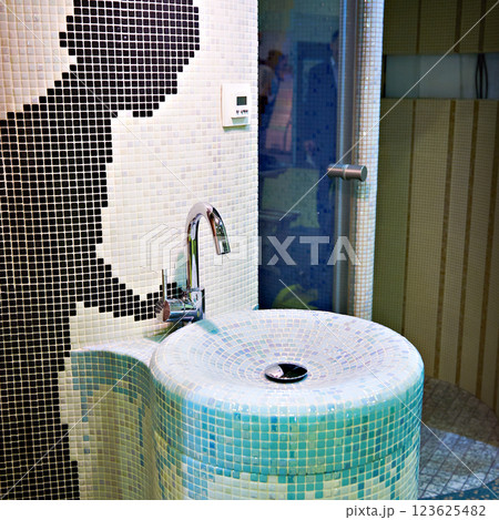 Faucet and sink in interior with small tiles Faucet and sink in interior with small tiles 123625482