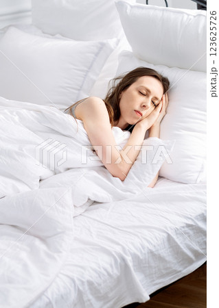 young woman sleeping on bed with white linen and air pillows. Correct regime and good sleep for female cycle young woman sleeping on bed with white linen and air pillows. Correct regime and good sleep for female cycle 123625726