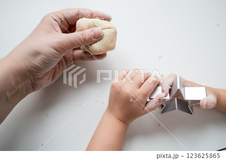 Caucasian child and adult baking together with star cookie cutter Caucasian child and adult baking together with star cookie cutter 123625865