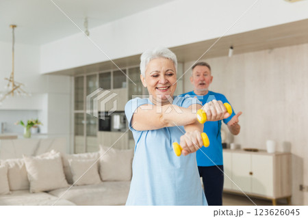 Fitness workout training. Senior woman picking up dumbbells. Old adult mature healthy lady doing sports exercise at home. Grandmother have workout rehabilitation. Health care healthy lifestyle Fitness workout training. Senior woman picking up dumbbells. Old adult mature healthy lady doing sports exercise at home. Grandmother have workout rehabilitation. Health care healthy lifestyle 123626045