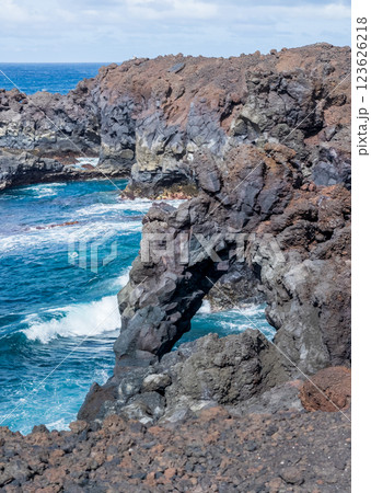 Majestic Ocean Waves Crash Against Volcanic Rock Formations Majestic Ocean Waves Crash Against Volcanic Rock Formations 123626218