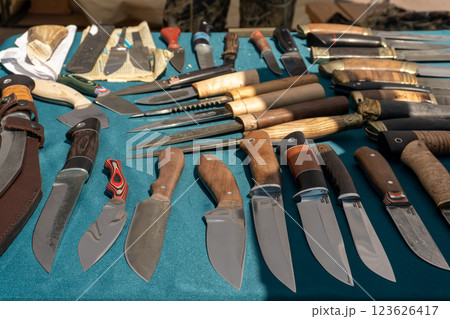 Knives on the counter of a craftsman. Sale of knives. A large selection of knives of different shapes and sizes. Knives on the counter of a craftsman. Sale of knives. A large selection of knives of different shapes and sizes. 123626417