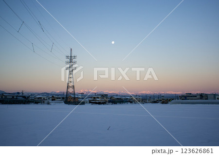雪が積もった畑と送電線の鉄塔 123626861