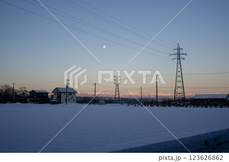 雪が積もった畑と送電線の鉄塔 雪が積もった畑と送電線の鉄塔 123626862