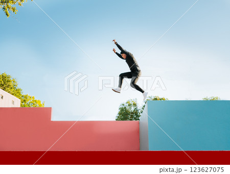 Guy doing parkour jumping colored walls. Guy doing jumping parkour at sunset. Side view of man doing parkour jumping walls Guy doing parkour jumping colored walls. Guy doing jumping parkour at sunset. Side view of man doing parkour jumping walls 123627075
