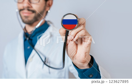 Doctor holding stethoscope with Russia flag. Russia health and care concept, Russia flag on stethoscope 123627895