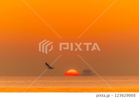 Omega sunrise over the sea in the morning with golden sunlight and see the Buddhist pavilion in the middle of the sea 123629008