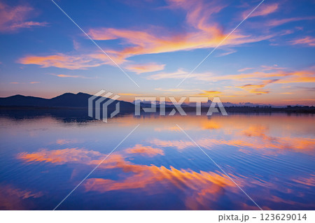 Landscape of mountains and lake at sunset and clouds reflected in the water. 123629014