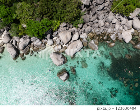 Rocky tropical coastline featuring clear waters and lush greenery under sunny skies. Nang Yuan, Koh Tao, Thailand. Rocky tropical coastline featuring clear waters and lush greenery under sunny skies. Nang Yuan, Koh Tao, Thailand. 123630404