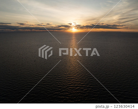 Wide view of the sea with the golden sun setting on the horizon casting warm reflections. Koh Tao, Thailand. 123630414
